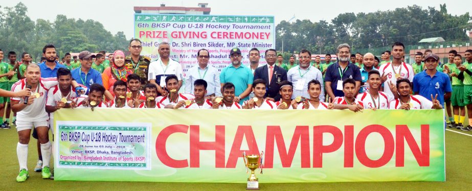 Members of BKSP Red team, the champions of the 6th Invitational International BKSP Cup Under-18 Hockey Tournament with the guests and officials of BKSP pose for photo at the BKSP Hockey Ground in Savar on Tuesday.