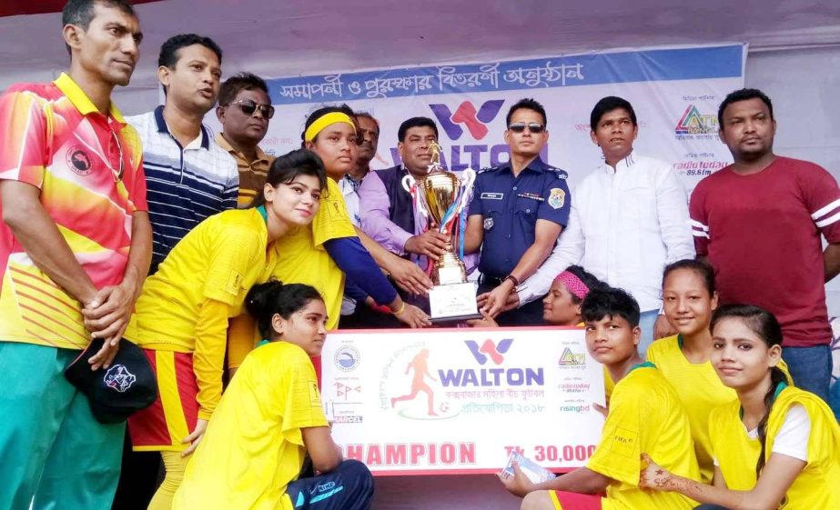 ' Brazil', the champions of the Walton 3rd Women's Beach Football Tournament with the guests and officials of Cox's Bazar District Sports Association pose for a photo session at the Laboni Point in Cox's Bazar Sea Beach on Tuesday.