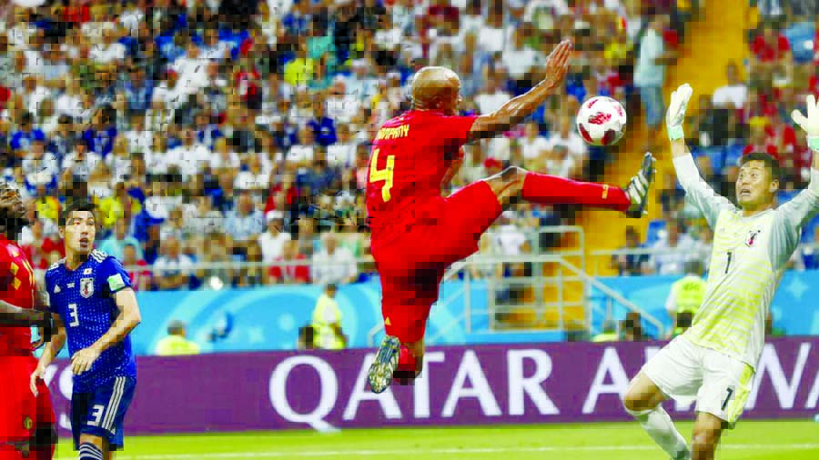 Players watching Belgium's Vincent Kompany jumping with the ball in front of Japan goalkeeper Eiji Kawashima during the round of 16 match between Belgium and Japan.