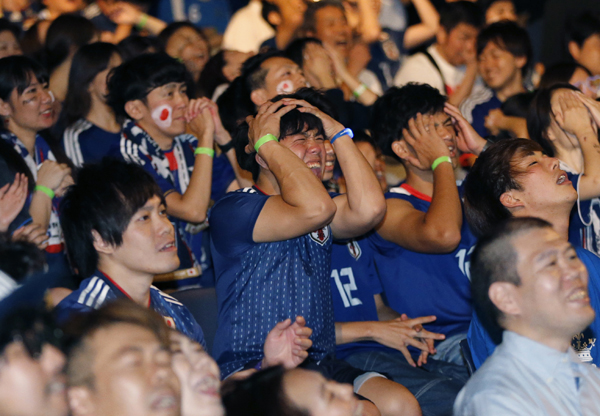 Supporters of Japan's soccer team react after Japan lost to Belgium in the World Cup soccer match, at a public viewing venue in Tokyo, on Tuesday.