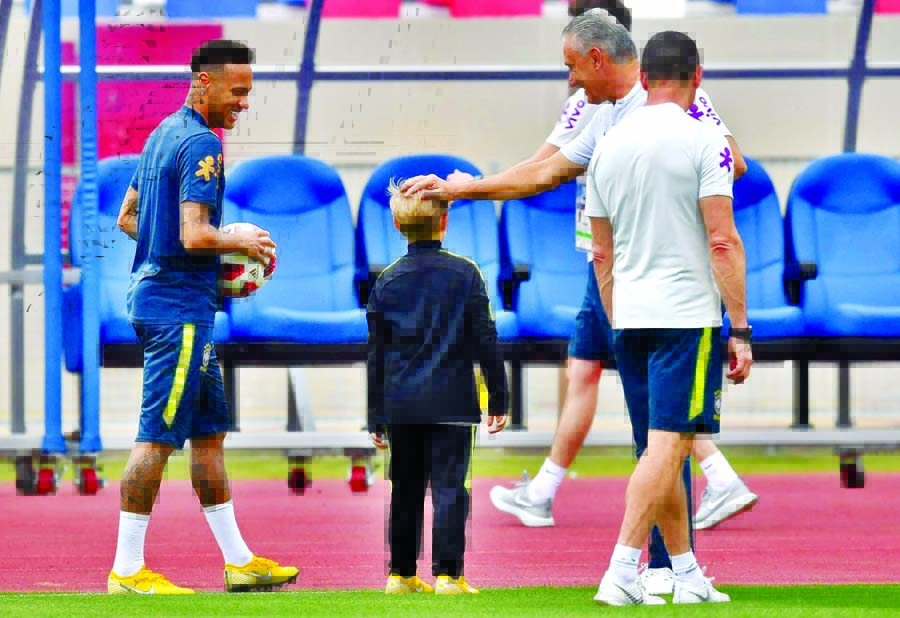 Neymar (L) stands past his son Davi Lucca (C) as Brazil's coach Tite touches his head during a training session at Yug Sport Stadium, in Sochi on Wednesday.