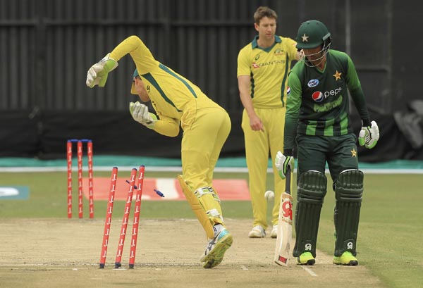 Australian wicketkeeper Alex Carey, left, attempts a run out in vain, during the T20 cricket match against Pakistan at Harare Sports Club, in Harare, Zimbabwe, Thursday, July 5, 2018. Zimbabwe is playing host to a tri-nation Twenty20 international series
