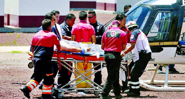 Paramedics wheel a stretcher carrying a man injured due to fireworks explosions toward a helicopter in the municipality of Tultepec, on the outskirts of Mexico City.
