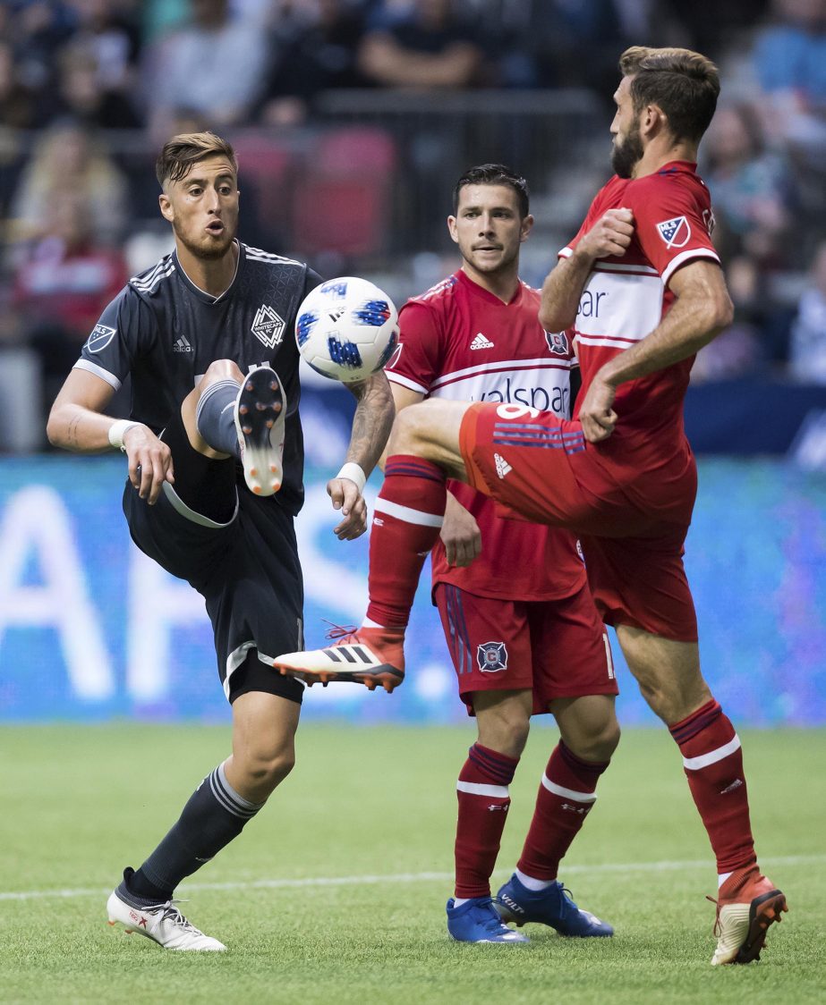 Vancouver Whitecaps' Jose Aja (left) and Chicago Fire's Jonathan Campbell (right) vie for the ball during the second half of a Major League Soccer match on Saturday in Vancouver, British Columbia.