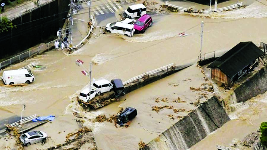 Floodwaters submerged homes and overturned cars over a wide area.