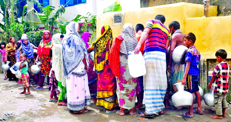 Local people in a queue to collect pure water from Gobindapur Government Primary School in the city's Sanir Akhra area on Monday.
