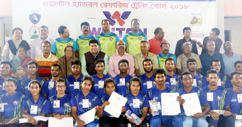 The participants of the handball referees' training course with the guests and officials of Bangladesh Handball Federation pose for a photo session at the Shaheed (Captain) M Mansur Ali National Handball Stadium on Monday.