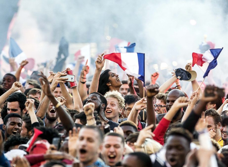 People react after France scored their side opening goal, outside the Paris town hall where soccer fans watch the World Cup semifinal match between France and Belgium on a giant screen, Tuesday.