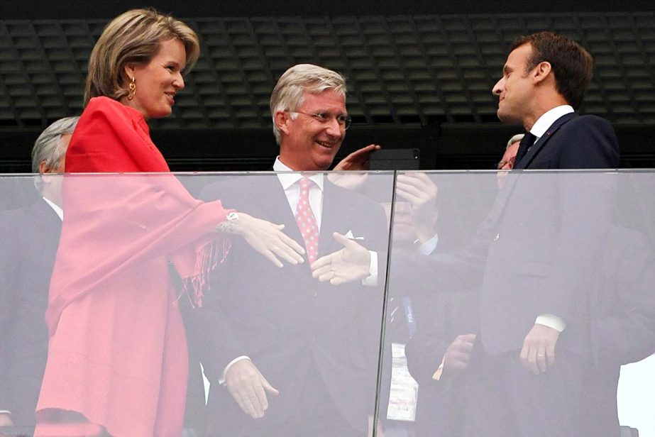 French President Emmanuel Macron greets Belgium's Queen Mathilde and King Philippe as they prepare to watch their countries do battle