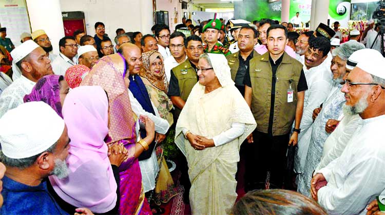 Prime Minister Sheikh Hasina exchanging greetings with Hajj pilgrims at the city's Ashkona Hajj Camp on Wednesday.