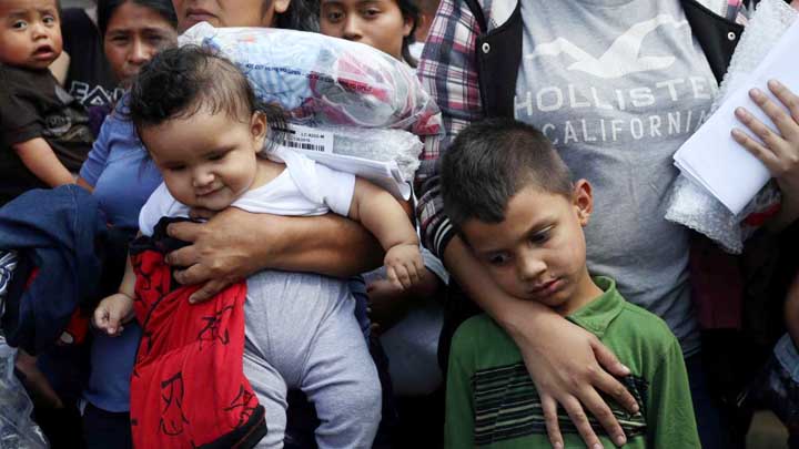 Immigrant children of undocumented immigrant families react as they are released from detention at a bus depot in McAllen, Texas.