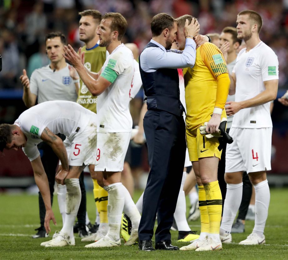 England head coach Gareth Southgate (center left) embraces England goalkeeper Jordan Pickford at the end of the semifinal match between Croatia and England at the 2018 soccer World Cup at the Luzhniki Stadium in Moscow, Russia on Wednesday.