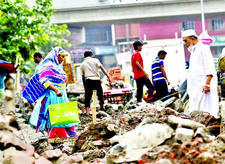 Piles of earth are left beside the dug up spot for long time for constructing sewage line in city's Malibagh Chowdhurypara area hindering smooth movement of local people. This picture was taken on Friday.