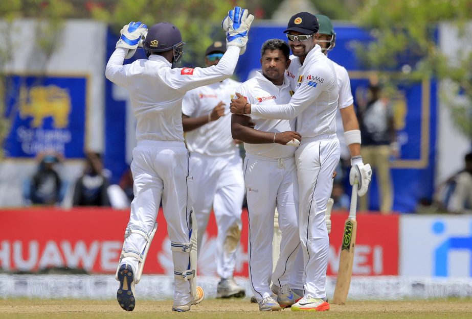 Sri Lanka's Rangana Herath (center without cap) celebrates the dismissal of South Africa's captain Faf du Plessis during the third day's play of their first test cricket match in Galle, Sri Lanka on Saturday.