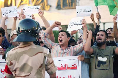 Iraqi protesters chant slogans demanding services and jobs during a demonstration in Tahrir Square on Saturday