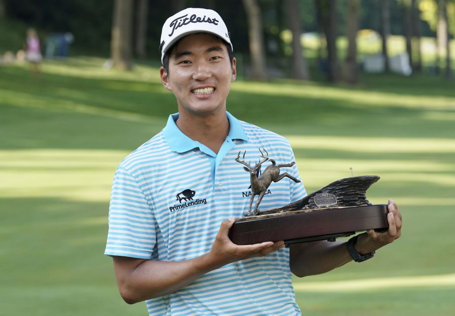 Michael Kim holds the trophy after winning the John Deere Classic golf tournament, Sunday at TPC Deere Run in Silvis, Ill.