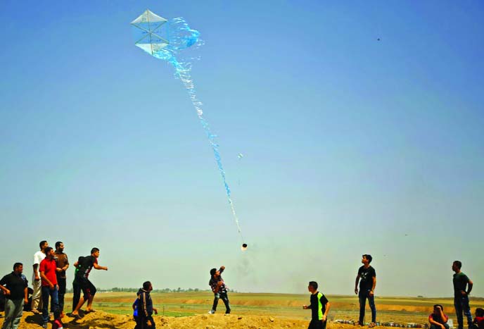 Palestinian protestors fly a kite loaded with an incendiary towards Israel during a demonstration along the border with Israel east of Jabalia in the central Gaza Strip.