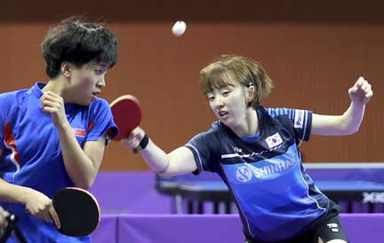 Combined team's South Korean Suh Hyo-won (right) returns a shot with teammate North Korean Kim Song I (left) during their women doubles preliminary round match against Uzbekistan's Olga Kim and Regina Kim at the ITTF World Tour Korea Open table tennis i