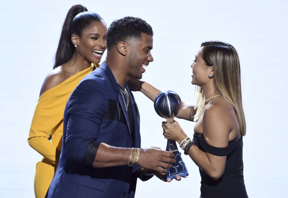 Ciara (left) and Seattle Seahawks' Russell Wilson present the award for best female athlete to snowboarder Chloe Kim at the ESPY Awards at Microsoft Theater on Wednesday in Los Angeles.