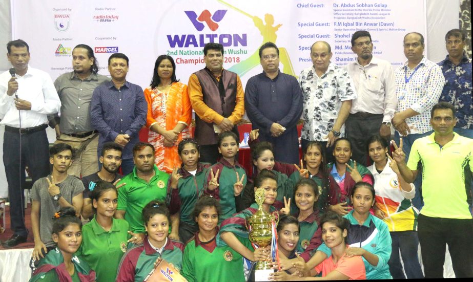 Bangladesh Ansar, the champions of the Walton 2nd National Women's Wushu Championship with the guests and officials of Bangladesh Wushu Association pose for a photo session at the Gymnasium of National Sports Council on Thursday.