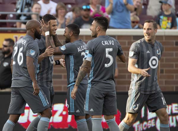 Minnesota United forward Christian Ramirez (21) is congratulated by teammate Alexi Gomez (32) after his goal during the first half of an MLS soccer match against the New England Revolution in Minneapolis on Wednesday.