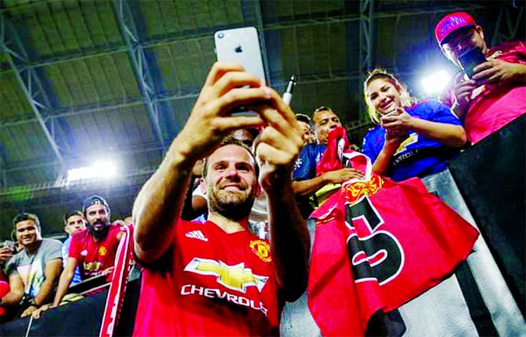 Juan Mata of Manchester United takes photos with fans after their International Champions Cup game against the Club America, at the University of Phoenix Stadium in Glendale, Arizona on Thursday.