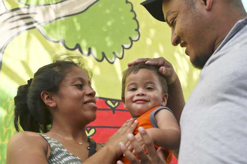 Adalicia Montecino holds her year-old son Johan Bueso Montecinos, who became a poster child for the US policy of separating immigrants and their children, as his father Rolando Bueso Castillo caresses Johan's head, at the Casa Belen shelter in San Pedro