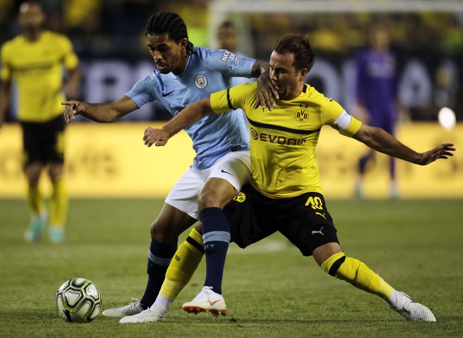 Manchester City midfielder Douglas Luis (left) battles over the ball with Borussia Dortmund midfielder Mario Gotze during the first half of an International Champions Cup tournament soccer match in Chicago on Friday.