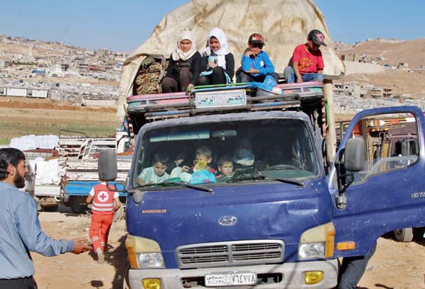 Syrian refugees ride a truck carrying their personal belongings at a Lebanese army checkpoint in Wadi Hmeid in the Bekaa valley, after leaving the village of Arsal to return to their homes in Syria's Qalamoun region.