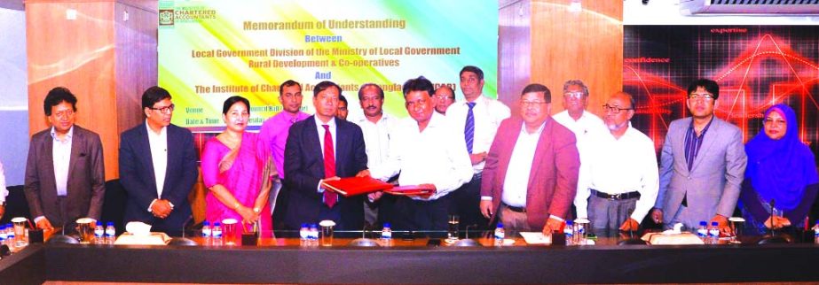 Dewan Nurul Islam, President of Institute of Chartered Accountants of Bangladesh (ICAB) and Sardar Sarafat Ali, Project Director (LGSP-3) of Local Government Division, exchanging a MoU signing documents at ICAB office in the city on Wednesday. Senior offi