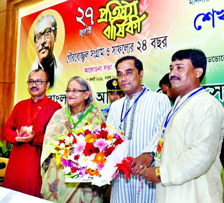 Prime Minister Sheikh Hasina being greeted with bouquet by President of Awami Swechchhasebak League (ASL) Advocate Molla Kawser and its Dhaka South General Secretary Arifur Rahman Titu at Ganabhaban on Friday marking the 24th founding anniversary of ASL.
