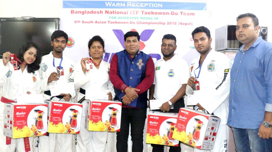 Senior Operative Director (Head of Games & Sports) of Walton Group FM Iqbal Bin Anwar Dawn with the members of Bangladesh Taekwondo team pose for photograph at the Walton office room in the city's Khilgaon on Saturday. Walton Group accorded a reception t