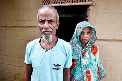 Abdul Suban, a farmer, and his wife pose for a photograph outside their home in Nellie village, in Morigaon district, in the northeastern state of Assam, India on Thursday.