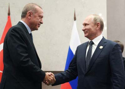 Turkey's President Recep Tayyip Erdogan shaking hands with Russian President Vladimir Putin before they pose for a group picture at the emerging national economies (BRICS) summit meeting in Johannesburg, South Africa on Saturday.