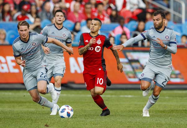 Toronto FC's Sebastian Giovinco battles for the ball with Chicago Fire's Jon Bakero (left) and Nemanja Nikolic (right) during the first half of an MLS soccer match in Toronto on Saturday.