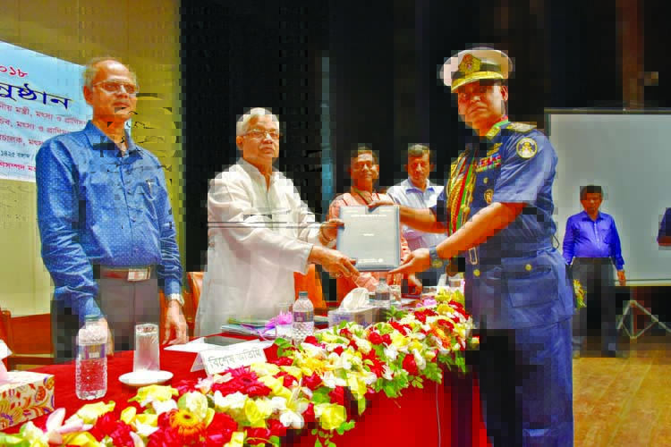 Fisheries and Livestock Minister Narayan Chandra Chanda handing over National Fishery Award to the Director General of Bangladesh Coastguard Admiral Awrangazeb Chowdhury at the National Museum in the city on Monday for his outstanding role in the fishery