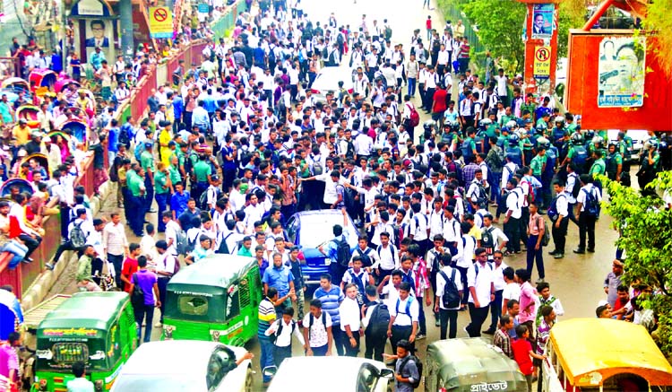 Angry students of Dhaka College, City Commerce College and Ideal College jointly blocked the Science Laboratory intersection protesting Sunday's bus crash that left two students of Shaheed Ramizuddin School and College in Kurmitola. The photo was taken f