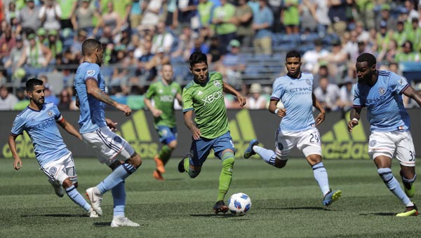 Seattle Sounders forward Raul Ruidiaz (center) splits a group of New York City FC players as he drives toward the goal during the second half of an MLS soccer match on Sunday in Seattle. The Sounders won 3-1.