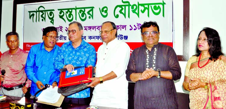 Newly elected President of BFUJ Molla Jalal taking charge from its former President Manjurul Ahsan Bulbul at a charge handing ceremony to the new committee held at the Jatiya Press Club on Tuesday.