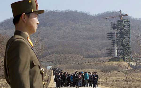 A crowd of media gather around a North Korean official on a road in front of North Korea's Unha-3 rocket, slated for liftoff between April 12-16, stands at Sohae Satellite Station in Tongchang-ri, North Korea . AP file photo