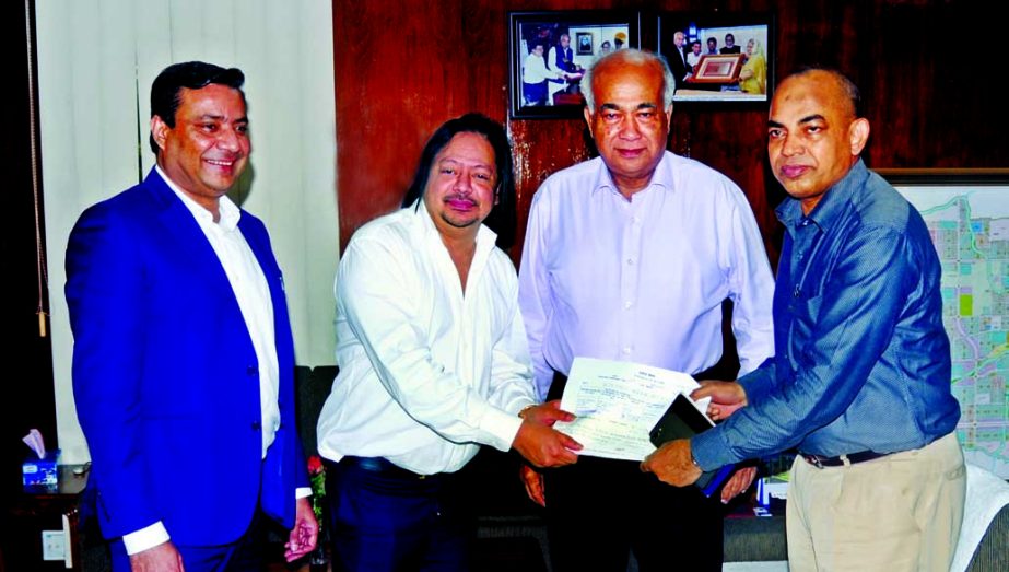 Ron Haque Sikder, Managing Director and Syed Qamrul Islam, Director of PowerPac Holdings Limited, handing over a Pay-Order to Engr. Mosharraf Hossain, Housing and Public Works Minister and Md. Abdur Rahman, Chairman RAJUK at the secretariat in Dhaka on M