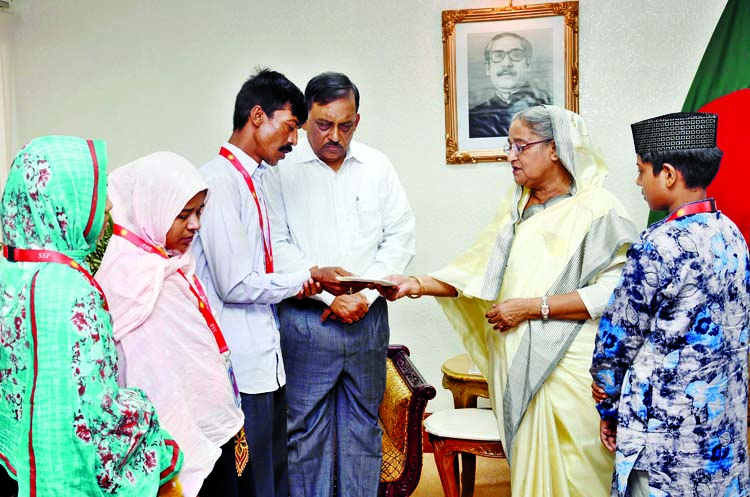 Prime Minister Sheikh Hasina handing over cheques of Taka twenty lakh to each of the families of two students who were killed in Kurmitola road accident when the family members of the deceased called on PM at her office on Thursday. PID photo