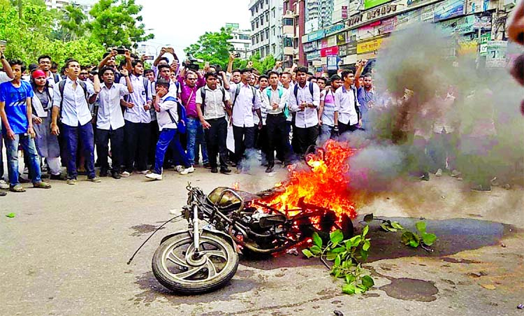 A group of agitating students set afire the motorbike of a traffic police sergeant at Science Laboratory intersection in city during students campaigning for safe roads on Thursday.