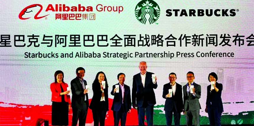 Starbucks CEO Kevin Johnson and Chief Executive Officer of Alibaba Group Holding Ltd. Daniel Zhang holds cups of Starbucks for a photo session at strategic partnership press conference in Shanghai, China on Thursday.