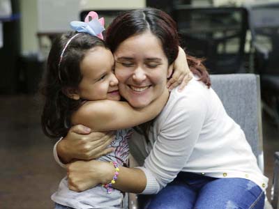 Natalia Oliveira da Silva and her daughter, Sara, 5, hug at a Catholic Charities facility in San Antonio, TX. They were separated in late May.