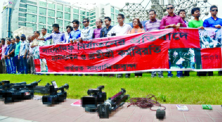 Journalists formed a human chain keeping their cameras on ground in front of SAARC Fountain in the city's Kawran Bazar on Tuesday in protest against repression on journalists.