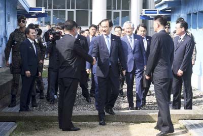 South Korean Unification Minister Cho Myoung-gyon, center, shakes hands with a North Korean official as he crosses to North Korea for the meeting at the northern side of Panmunjom in the Demilitarized Zone, North Korea on Monday.