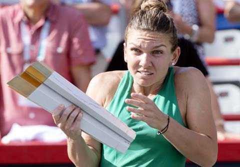 Simona Halep of Romania, reacts as the streamer cannon is fired during the victory ceremony after defeating Sloane Stephens of the United States in the final at the Rogers Cup women's tennis tournament in Montreal on Sunday.