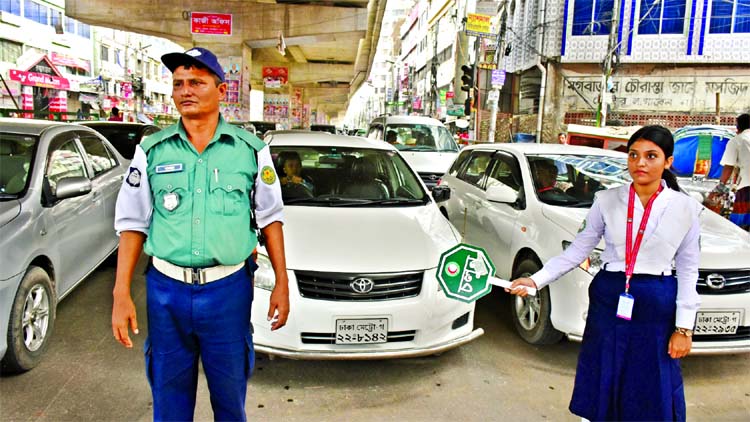 A girl scout in cooperation with traffic police trying to create awareness among the people about traffic discipline on roads. This photo was taken from Moghbazar area on Monday.