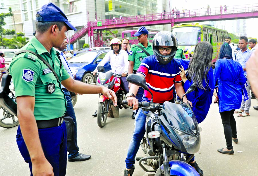A girl scout in cooperation with traffic police trying to create awareness among the people about traffic discipline on roads. This photo was taken from Moghbazar area on Monday.